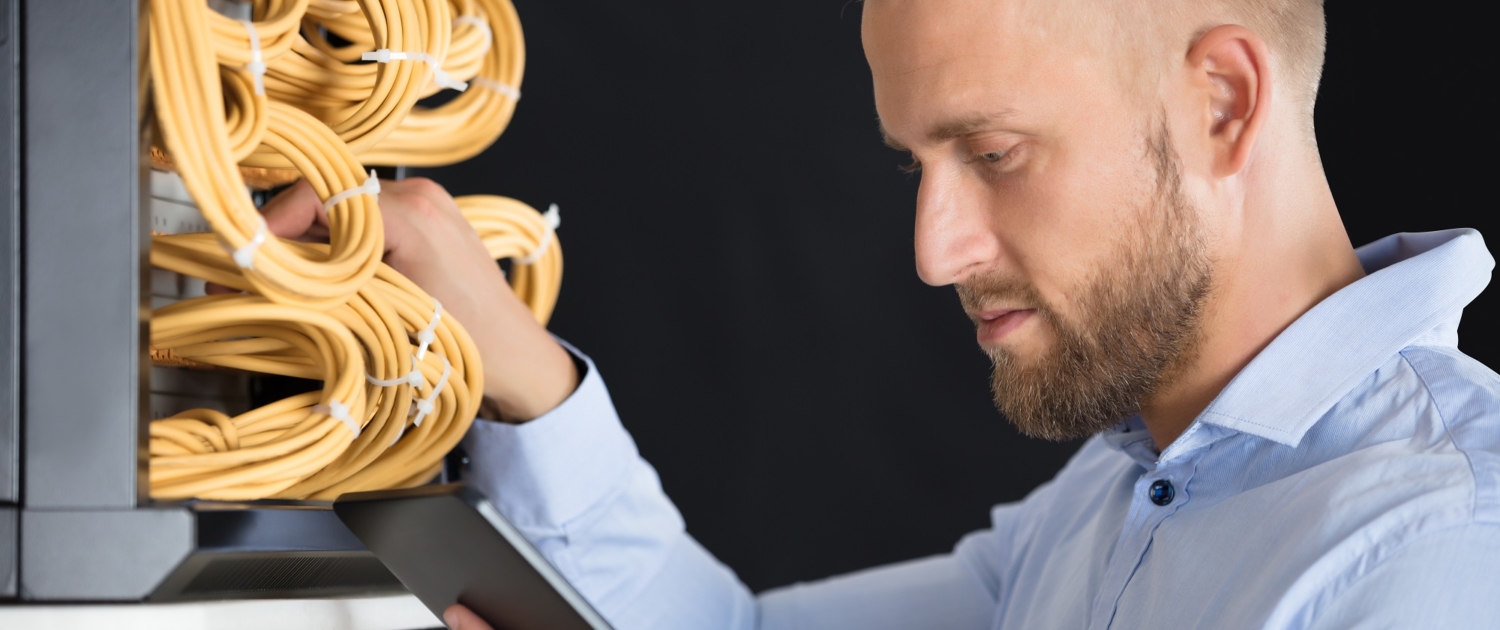 Technician Checking Server's Wires In Data Center